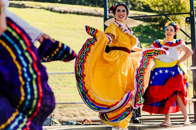 cazateatro dancers perform on stage in colorful cultural dresses