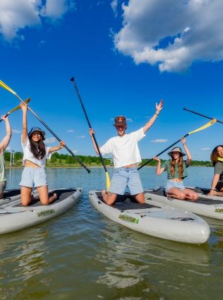 teens pose on paddle boards for photo