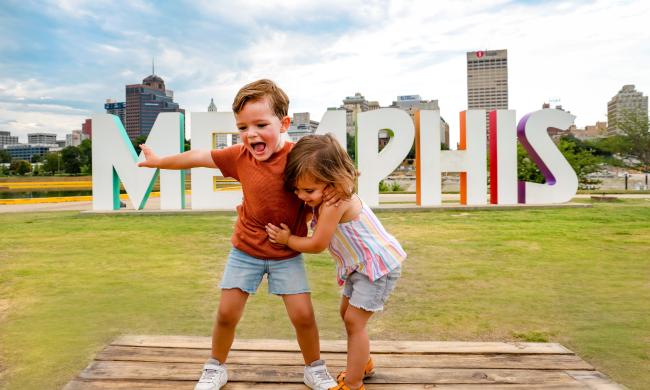 Kids pose in front of Memphis Sign on Mud Island