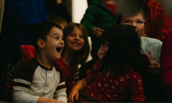 Kids smiling and enjoying programming at the Brooks Museum of Art.