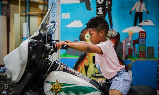 Child sits on a police motorcycle inside the Children's Museum of Memphis.