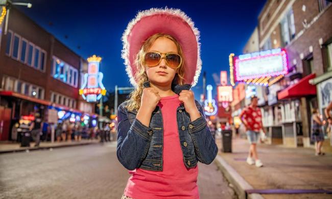 Girl with a pink cowboy hat on Beale Street.