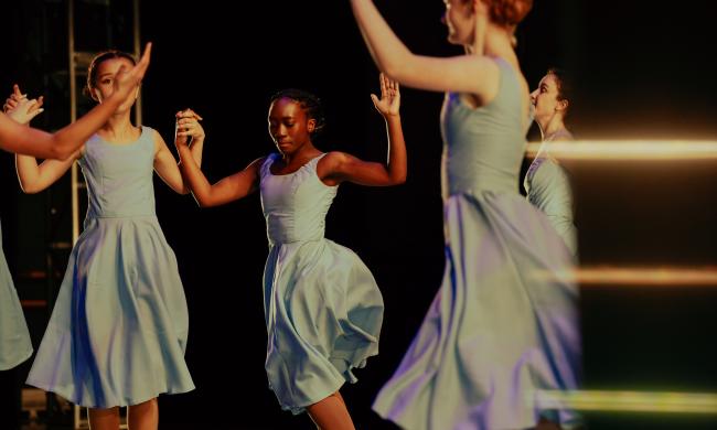 woman perform ballet on stage in blue dresses
