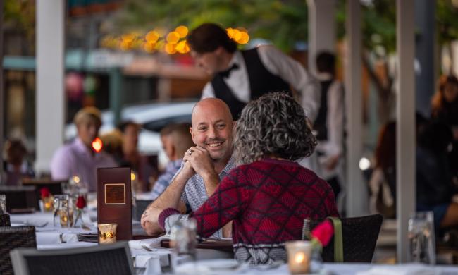 man and woman dine on the patio of Porch &amp; Parlor