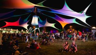 Guests relax around the grounds of Mempho Music Festival. Multicolored tents provide shade.