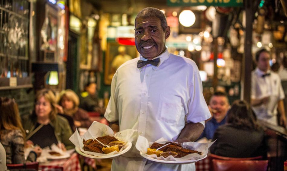 Server smiles holding up plates Rendezvous Ribs